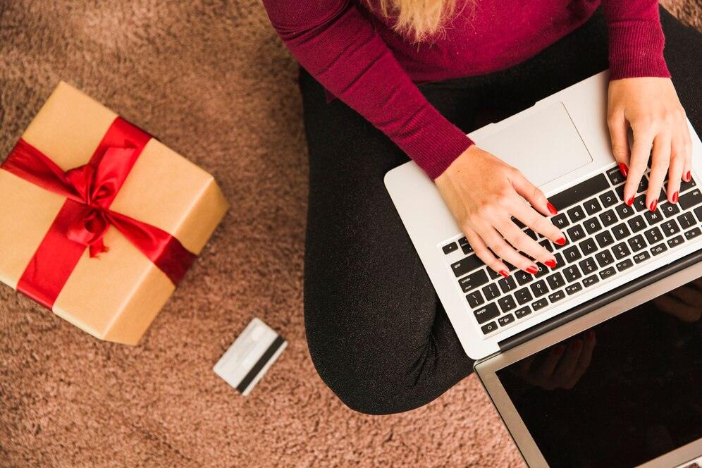woman-with-laptop-near-plastic-card-present-box_23-2147973967
